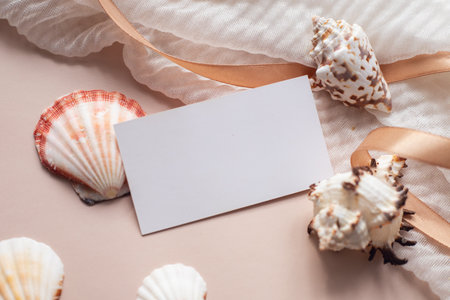 Mockup of business card with collection of shells on pink background with fabric and ribbons. Blank...