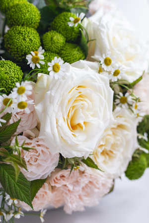Beautiful bouquet of white roses, pink carnations, small daisies and raspberry stems. Professional flower arrangement of pastel colored buds close-up. Wedding elegant bouquet. Flower shopの写真素材