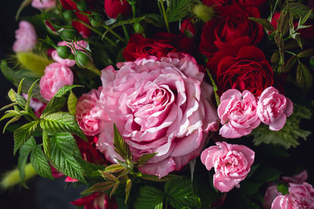 Close-up floral background featuring blooming pink roses, alstroemeria and raspberry leaves. Elegant bouquet suitable for wedding invitations, flower shops, beauty brands and gift concepts