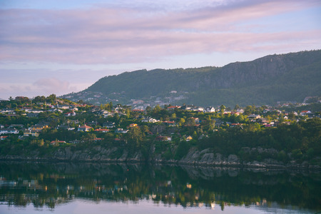 Pink clouds in the sky over the fjord at dawn and and reflected on the surface of the bay's water.  Norway, Bergen. Early morning.の写真素材