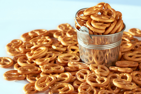 A full bucket of delicious golden pretzel close-up macro and sunlight and a lot of pretzels on the white background.の写真素材