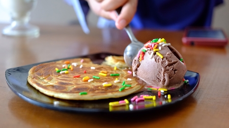 people eating ice cream and maryam bread in a black plateの写真素材