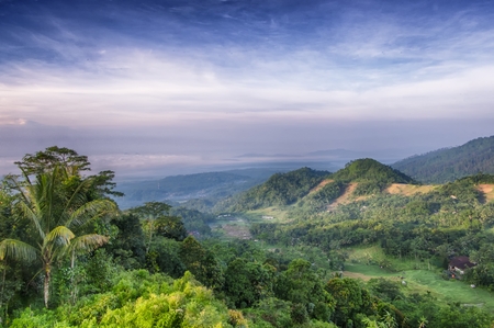 Epic scenery of forests and hills, photographed from above, with blue skies but cloudy