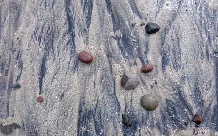 Beautiful formation of red, black and green rock on black and brown sand, captured on the tropical beach. Captured on Menganti Beach, Kebumen, Indonesiaの写真素材