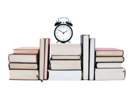 Books stacked with clock, isolated on white backgroundの写真素材