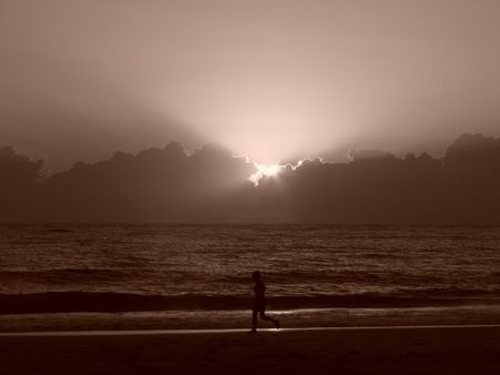 Jogging on the beach at sunsetの写真素材