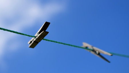 clothespins on rope and blue sky as background