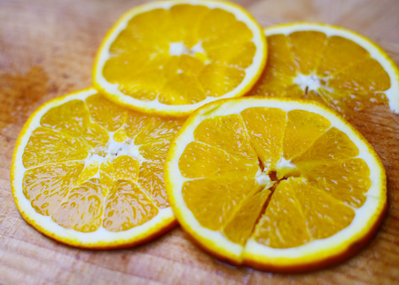 Fresh and fruity orange in wooden plate. Preparing of juice in kitchen. Food background.の写真素材