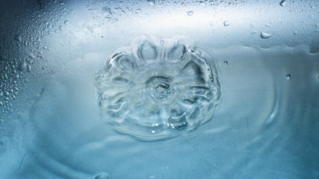 detail of water drop falling into water surface. Beautiful nature.