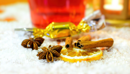 Detail of a punch ingredients - cinnamon, badyan and fruit. Winter hot drink background with white snow.の写真素材