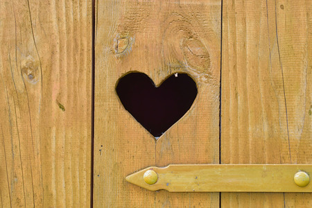 Detail of a heart on door of wooden toilet.の写真素材