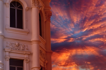 Cloudy sky and sun rays on a tower facadeの写真素材
