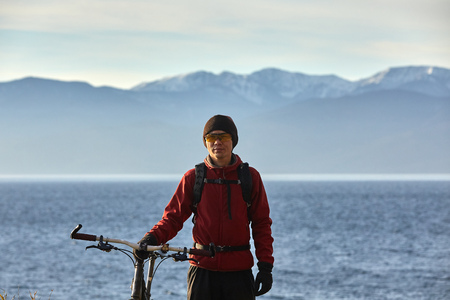 Tourist rides a bike with wide wheels along the shore of Lake Baikal.の写真素材