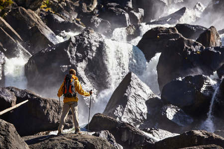 Happy man with backpack enjoying amazing waterfall Travel Lifestyle and success concept vacations into the wild natureの写真素材