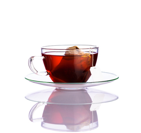 Single Cup of red fruit tea in glass cup with tea-bag isolated on white backgroundの写真素材