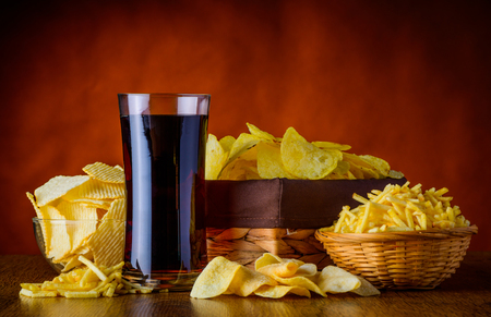 Different Types of Potato-snacks and glass of Cola, unhealthy foodの写真素材