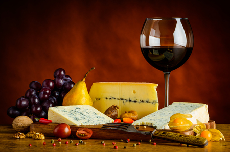 Blue Cheese, gorgonzola, morbier, grapes and red glass wineの写真素材