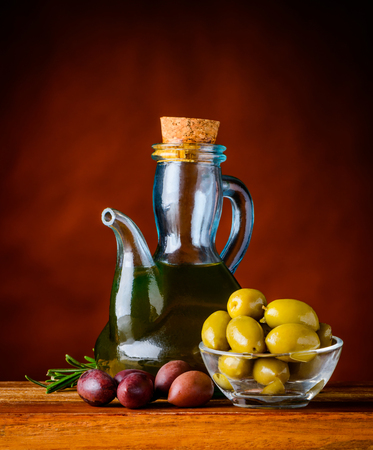 Olive oil in bottle with light and dark olivesの写真素材