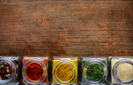 Pepper, curry powder, thyme food spices in glass jars with copy spaceの写真素材