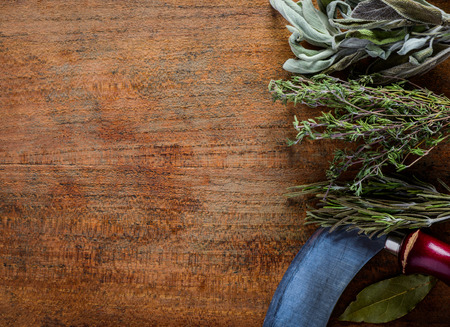 Copy Space and Green Herbs with herbchopper on wooden background. Rosemary, bay leaf, sageの写真素材