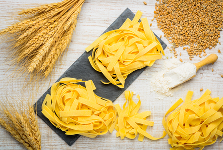 Top view of Yellow Tagliatelle Fetticcine Pasta with whteat and flourの写真素材