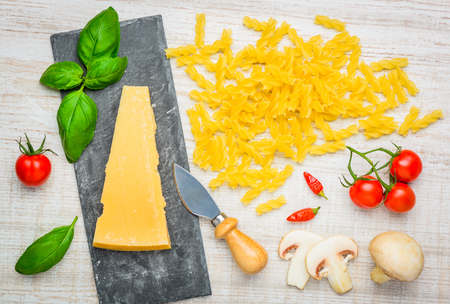 Yellow Fusilli Pasta with Parmesan cheese and basil, tomato and mushroomsの写真素材