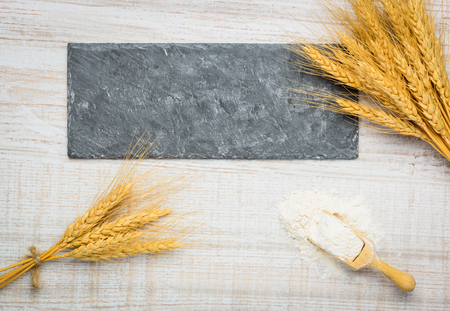 Copy Space on Dark Stone Plate with Wheat and Flourの写真素材