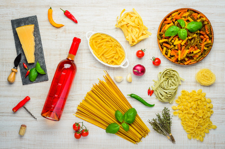 Bottle of rose Wine with Italian Pasta and Parmesan cheese and cooking ingredientsの写真素材