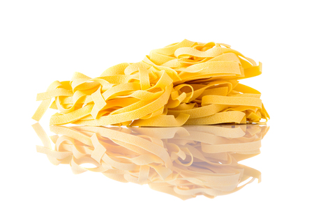 Italian yellow Tagliatelle tagliolini pasta isolated on white background. Mediterranean or italian cuisineの写真素材