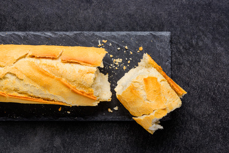 Loaf of Broken French Bread on a dark Background