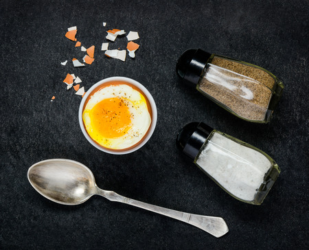 Organic Chicken Egg with Salt and Pepper on Dark Backgroundの写真素材