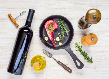 Frying Pan with Lamb Ribs and Bottle of Red Wine with Spicesの写真素材