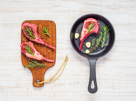 Lamb Chops Ribs Meat in Frying Pan and on Wooden Chopping Board in Top Viewの写真素材