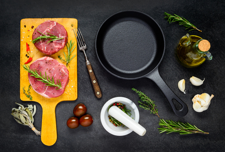 Raw Meat with Black Iron Frying Pan and Cooking Ingredients on Top Viewの写真素材