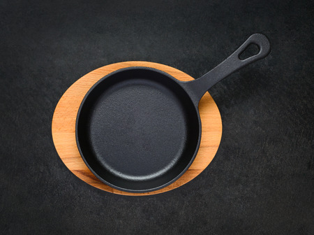 Top View of Empty Black Iron Frying Pan on Wooden Boardの写真素材