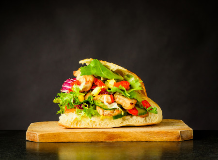 Tasty Looking Doner Kebap Sandwich with Fresh Vegetables on Wooden Boardの写真素材