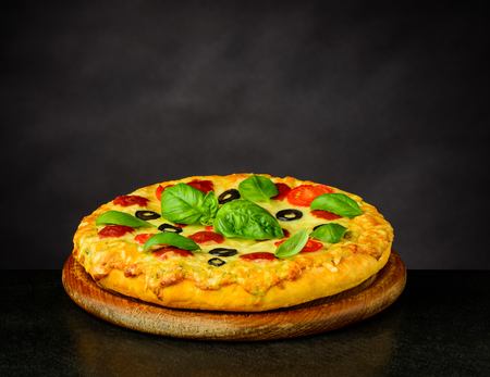 Tasty looking Pizza Margherita on Wooden Chopping Boardの写真素材
