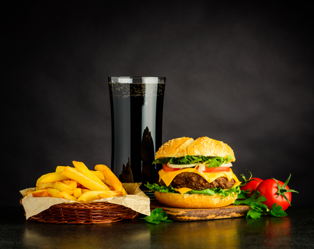 Tasty Looking Cheeseburger with Cola and French Fries on Dark Backgroundの写真素材