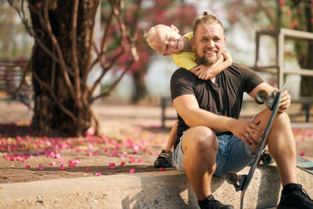 Father is having fun together with his little son in skate park Springtime. Portraitの写真素材