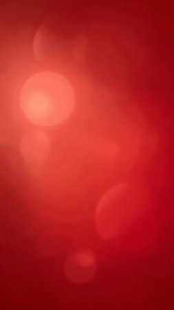 Soft red gradient with glowing bokeh circles creates a warm, minimalist abstract background.の素材