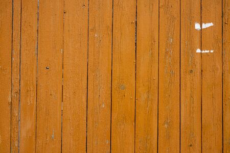 Background image of a wooden fence. Texture of painted wood. The texture of the old paint. Cracks in the paint. Wooden boards. Old fence painted with yolk paint. Text space. Wallpaper.の写真素材