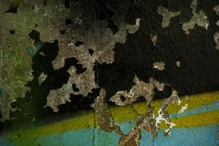 The texture of the old concrete wall covered with paint. Texture of cracked old paint. A background image of a helmet painted wall. Old graffiti on a concrete wall shot at close range. Graphic resources abstract textured background.の写真素材