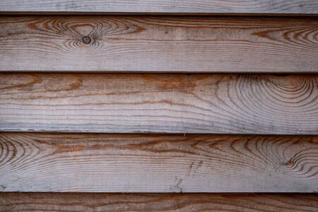 Background image of a wooden wall. Wood texture. Wooden boards. Wooden fence. Text space. Wallpaper. Texture for exterior and interior. Natural materials in construction. Ecological home decoration.の写真素材