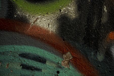 The texture of the old concrete wall covered with paint. Texture of cracked old paint. A background image of a helmet painted wall. Old graffiti on a concrete wall shot at close range. Graphic resources abstract textured background.の写真素材