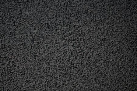 Background image of a rough painted wall. Rough surface texture. Decorative plaster. Monotonous wallpapers. Finishing materials for the interior. Moisture resistant, washable coating.の写真素材