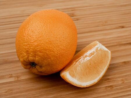 Orange on a wooden background. Wooden plank. Harvest fresh oranges. Ripe fruit. Wood texture. Orange peel. A slice of orange. Peeled orange. Vitamin C. Fruit diet. Background image of fruit.の写真素材