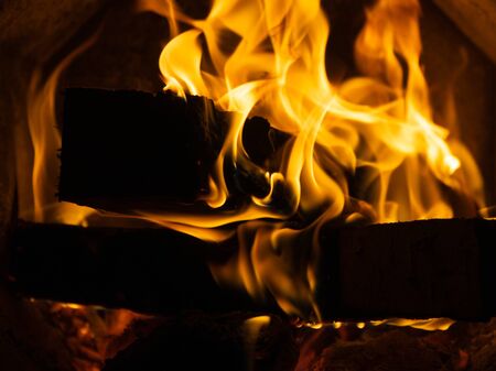 Fire in the stove. Tongues of flame. Firewood burns in the stove. Birch firewood. Open fire. Heated...