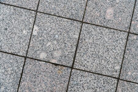 Background image of pavement surface. Wallpaper. Substrate for text. Detailed texture of a pedestrian walkway with paving tiles. Paving slabs in the exterior.の写真素材