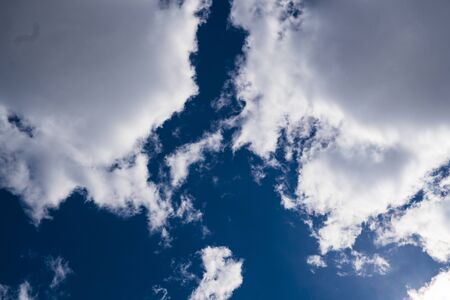Background image of blue sky with clouds. Sunlight breaking through the cloudsの写真素材