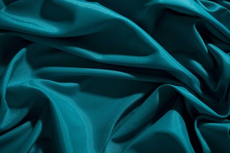 Background image of crumpled fabric. Blue silkの写真素材